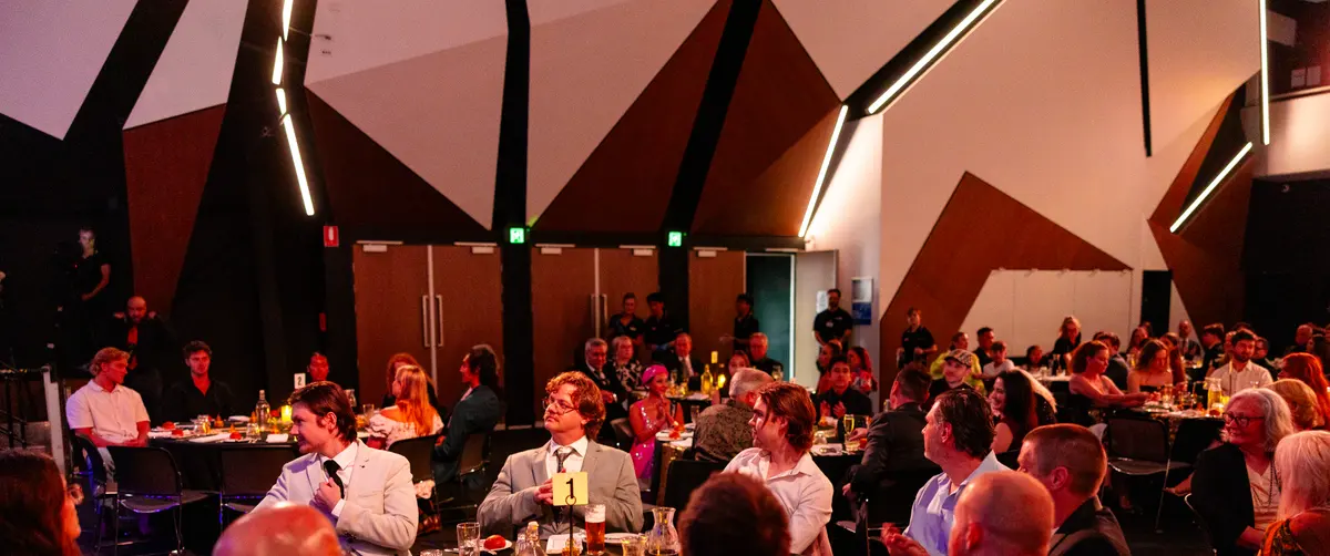 The full gala room at the AFIN 2025 Awards Night, guests at dinner tables under the venue's angled timber ceiling.